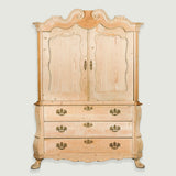 A large stripped pine armoire with shaped crest over panelled doors and three-drawer  bombe base. Circa 1760 Dutch.