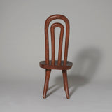 A rustic low side chair with a double hoop back and wooden seat, Madagascar, 20th century.