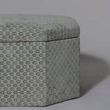 A rectangular ottoman stool with canted corners upholstered in a grey/blue gauffraged velvet, with hinged lid, the interior contrast lined in grey ticking.