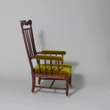 A mid-19th century open armchair with high bobbin turned spindle back and carved toprail and rosewood graining.