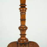 A small round table with a painted faux marquetry top and a turned central support on a tripod base. Early 19th century.