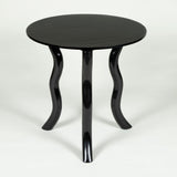 Low round teak tables with serpentine legs in a polished or an ebonised finish.