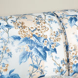 A large three seat sofa in a traditional style upholstered in a floral chintz fabric in blues and browns on a white ground.