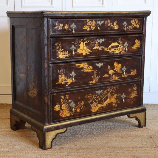 A LATE 19TH CENTURY CONTINENTAL FOUR DRAWER JAPANNED COMMODE WITH CHINOISERIE DECORATION, BRACKET FEET AND DROP HANDLES.