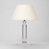 A MID-20TH CENTURY LUCITE AND BRASS COLUMN ON A SQUARE BASE WIRED AS A LAMP.
