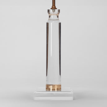 A MID-20TH CENTURY LUCITE AND BRASS COLUMN ON A SQUARE BASE WIRED AS A LAMP.