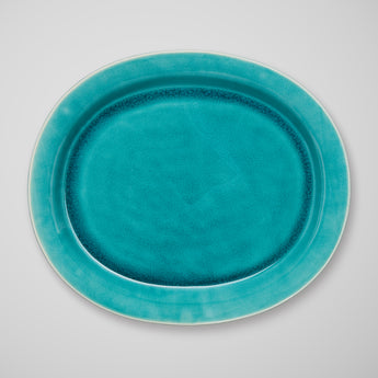 AN OVAL PLATTER IN A TURQUOISE GLAZE.