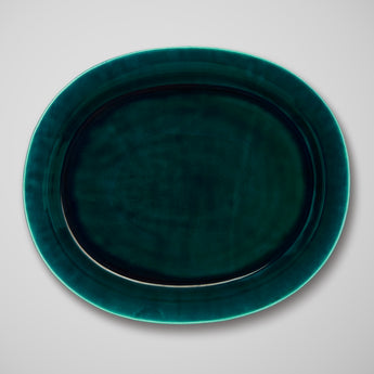 AN OVAL PLATTER IN A DEEP TEAL GLAZE.