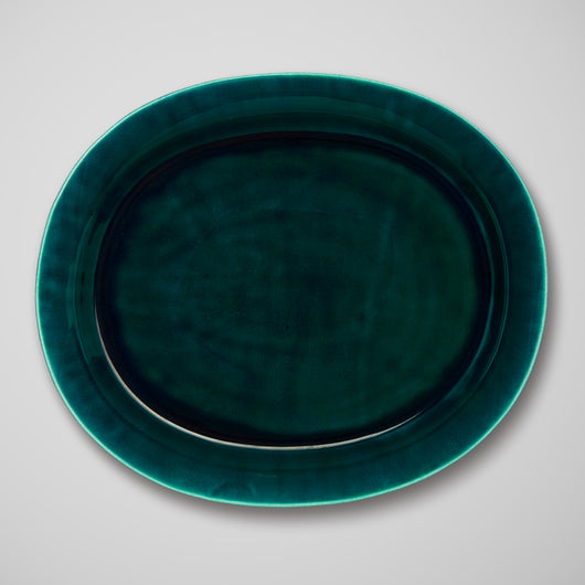 AN OVAL PLATTER IN A DEEP TEAL GLAZE.