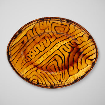 AN LARGE OVAL PLATTER IN A MUSTARD GLAZE.