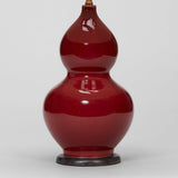 A PAIR OF 1970'S DOUBLE GOURD VASES WITH A SANG DE BOEUF GLAZE IN THE CHINESE MANNER, WIRED AS LAMPS.