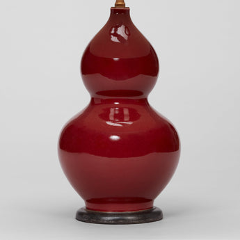 A PAIR OF 1970'S DOUBLE GOURD VASES WITH A SANG DE BOEUF GLAZE IN THE CHINESE MANNER, WIRED AS LAMPS.