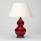 A PAIR OF 1970'S DOUBLE GOURD VASES WITH A SANG DE BOEUF GLAZE IN THE CHINESE MANNER, WIRED AS LAMPS.