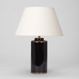 A PAIR OF SMALL BLACK POTTERY CYLINDER VASES AND A SINGLE LARGER VERSION,  WITH BRASS BANDS TO THE RIMS,  WIRED AS LAMPS.