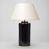 A PAIR OF SMALL BLACK POTTERY CYLINDER VASES AND A SINGLE LARGER VERSION,  WITH BRASS BANDS TO THE RIMS,  WIRED AS LAMPS.