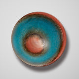 A STUDIO POTTERY DISH IN A TURQUOISE AND COPPER GLAZE.