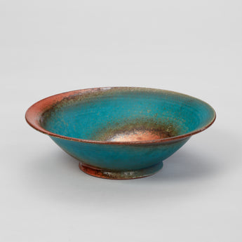 A STUDIO POTTERY DISH IN A TURQUOISE AND COPPER GLAZE.