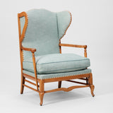 A COTSWOLD STYLE PALE OAK WING ARMCHAIR WITH A SERPENTINE BACK AND TURNED-OUT ARMRESTS. CIRCA 1930.