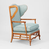 A COTSWOLD STYLE PALE OAK WING ARMCHAIR WITH A SERPENTINE BACK AND TURNED-OUT ARMRESTS. CIRCA 1930.