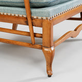 A COTSWOLD STYLE PALE OAK WING ARMCHAIR WITH A SERPENTINE BACK AND TURNED-OUT ARMRESTS. CIRCA 1930.