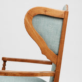 A COTSWOLD STYLE PALE OAK WING ARMCHAIR WITH A SERPENTINE BACK AND TURNED-OUT ARMRESTS. CIRCA 1930.