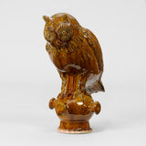 A POTTERY OWL FIGURINE IN A BROWN GLAZE, WITH SEPARATE STAND