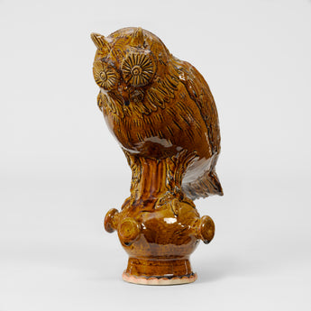 A POTTERY OWL FIGURINE IN A BROWN GLAZE, WITH SEPARATE STAND