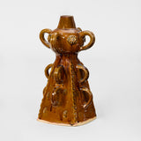 A POTTERY OWL FIGURINE IN A BROWN GLAZE, WITH SEPARATE STAND