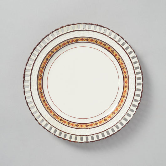 A CREAMWARE STAFFORDSHIRE PLATE WITH BASKETWEAVE BORDER AND A BAND OF FLOWER HEAD DECORATION, CIRCA 1810.