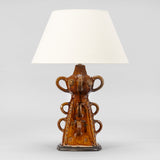 A FRENCH BROWN GLAZED POTTERY PYRAMIDAL-SHAPED STAND WITH LOOP HANDLES AND INCISED DECORATION WIRED AS A LAMP.