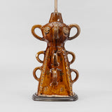 A FRENCH BROWN GLAZED POTTERY PYRAMIDAL-SHAPED STAND WITH LOOP HANDLES AND INCISED DECORATION WIRED AS A LAMP.