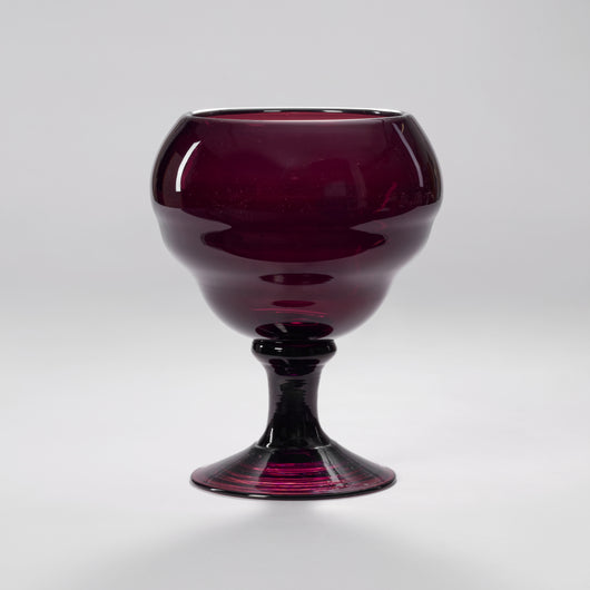 A GOBLET SHAPED AMETHYST GLASS VASE.