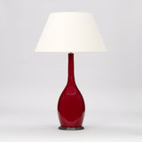 A TALL VASE WITH A SLENDER NECK, THE BULBOUS BASE WITH IMPRESSED SIDES AND A DEEP RED GLAZE, WIRED AS A LAMP.