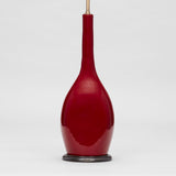A TALL VASE WITH A SLENDER NECK, THE BULBOUS BASE WITH IMPRESSED SIDES AND A DEEP RED GLAZE, WIRED AS A LAMP.