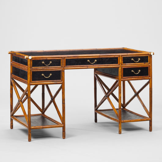 A 1950s BAMBOO FRAMED DESK WITH EBONISED RATTAN PANELS AND PAIRS OF DRAWERS SET ABOVE SHELVES.
