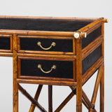 A 1950s BAMBOO FRAMED DESK WITH EBONISED RATTAN PANELS AND PAIRS OF DRAWERS SET ABOVE SHELVES.