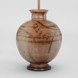 AN ART POTTERY VASE BY W.A. WELLOWAY IN THE JAPANESE TASTE, OF SPHERICAL SHAPE WITH BROWN MARKINGS TO THE RIBBED BODY. DATED 1947. WIRED AS A LAMP.