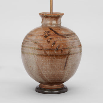 AN ART POTTERY VASE BY W.A. WELLOWAY IN THE JAPANESE TASTE, OF SPHERICAL SHAPE WITH BROWN MARKINGS TO THE RIBBED BODY. DATED 1947. WIRED AS A LAMP.