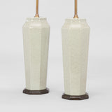A PAIR OF FACETTED VASES OF TAPERING OCTAGONAL FORM IN A MOTTLED CELEDON GLAZE WIRED AS LAMPS.