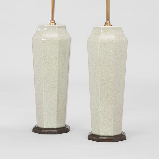 A PAIR OF FACETTED VASES OF TAPERING OCTAGONAL FORM IN A MOTTLED CELEDON GLAZE WIRED AS LAMPS.