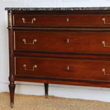 A 19TH CENTURY THREE-DRAWER MAHOGANY COMMODE IN THE LOUIS XVI TASTE, WITH A GREY MARBLE TOP AND BRASS MOUNTS.
