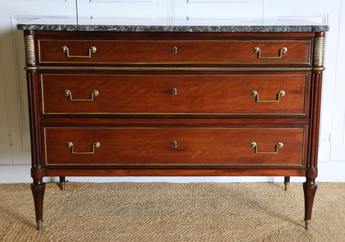 A 19TH CENTURY THREE-DRAWER MAHOGANY COMMODE IN THE LOUIS XVI TASTE, WITH A GREY MARBLE TOP AND BRASS MOUNTS.