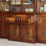 AN EARLY 19TH CENTURY ENGLISH REGENCY MAHOGANY BREAKFRONT SECRETAIRE BOOKCASE, WITH ASTRAGAL GLAZED DOORS AND WRITING FALL.
