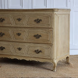 A 19TH CENTURY FRENCH BLEACHED OAK THREE DRAWER COMMODE.