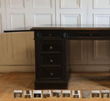 A GOOD QUALITY LATE NAPOLEON III, FRENCH PEDESTAL DESK, RETAINING THE ORIGINAL EBONISED FINISH, WITH NINE DRAWERS AND WITH ITS ORIGINAL TOOLED LEATHER TOP AND BRUSHING SLIDES. FRENCH, CIRCA 1880S