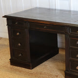 A GOOD QUALITY LATE NAPOLEON III, FRENCH PEDESTAL DESK, RETAINING THE ORIGINAL EBONISED FINISH, WITH NINE DRAWERS AND WITH ITS ORIGINAL TOOLED LEATHER TOP AND BRUSHING SLIDES. FRENCH, CIRCA 1880S