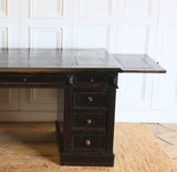 A GOOD QUALITY LATE NAPOLEON III, FRENCH PEDESTAL DESK, RETAINING THE ORIGINAL EBONISED FINISH, WITH NINE DRAWERS AND WITH ITS ORIGINAL TOOLED LEATHER TOP AND BRUSHING SLIDES. FRENCH, CIRCA 1880S
