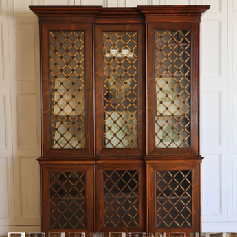 A VERY ELEGANT, 19TH CENTURY ENGLISH WILLIAM IV PERIOD INVERTED BREAKFRONT BOOKCASE IN ROSEWOOD, THE GLAZED DOORS WITH LATTICE AND ROSETTE BRASS GRILLS.