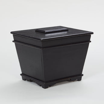 A SARCOPHAGUS SHAPED COAL BOX WITH LIFT-UP LID AND AN EBONISED FINISH. LATE 19TH, EARLY 20TH CENTURY.