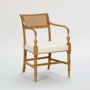 A MATCHED PAIR OF EARLY 19TH CENTURY ELBOW CHAIRS WITH RATTAN BACKS AND LINE DETAILING TO THE SAND-COLOURED PAINTWORK.